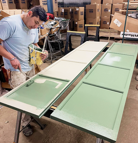 Jerry painting a wood with green paint